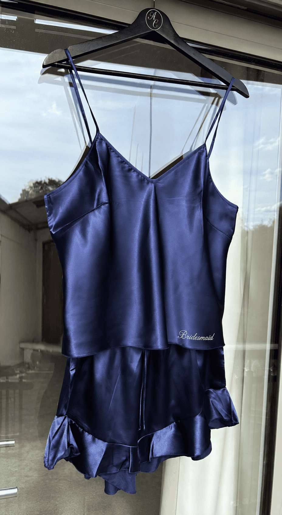 Elegant navy satin bridal party pajamas with ruffle details and adjustable straps.